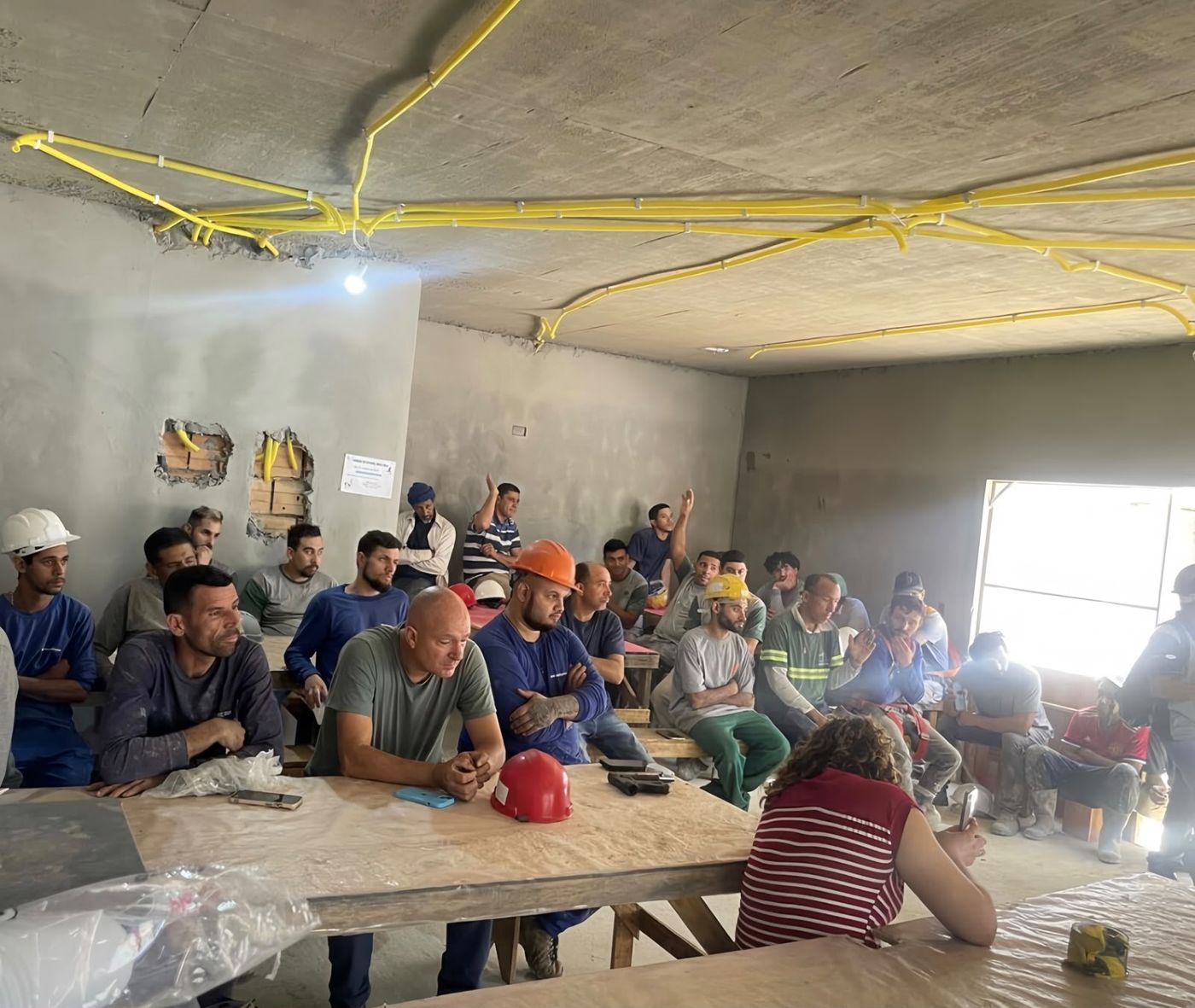 Turma de treinamento reunida no canteiro de obras